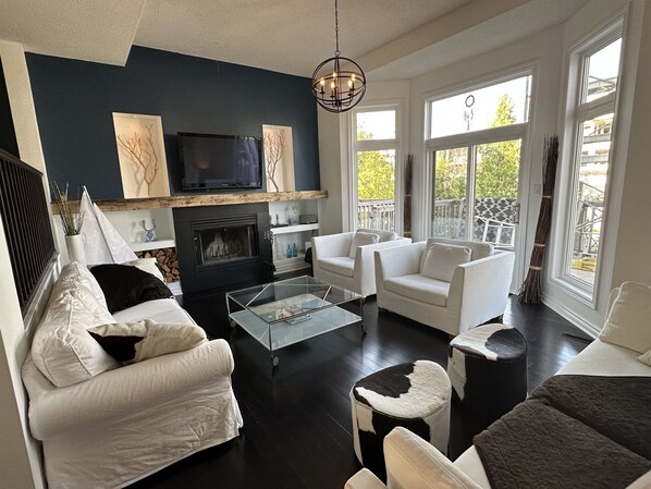 Living room with vaulted ceiling and wood burning fireplace. 