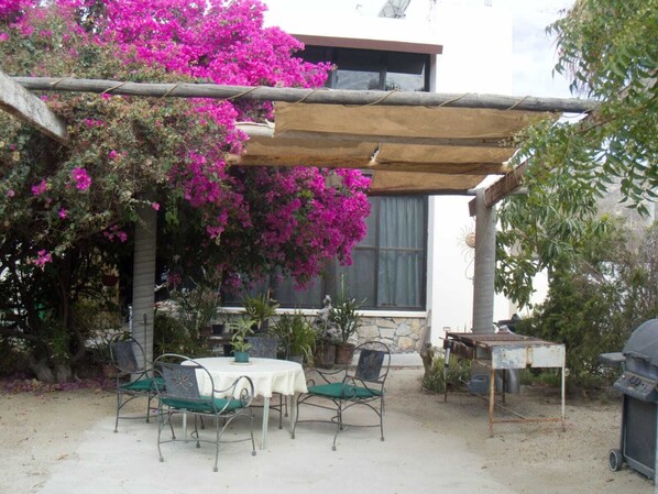 Jardín grande con asador y mesa para comer o solo disfrutar el ambiente