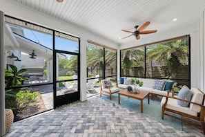 Screened in lanai off of the primary bedroom and living room. Turn on the ceiling fans for an additional breeze or lower the privacy curtains at night for additional privacy.