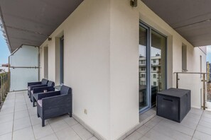 A spacious balcony with outdoor seating, ideal for enjoying fresh air and relaxation.
