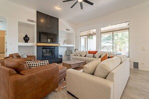 Dining room with lots of seating with a gas fireplace and smart TV with Roku.