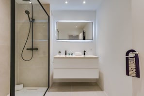 The bathroom is modern and features a walk-in rain shower, which is a great way to wake up and start the day.