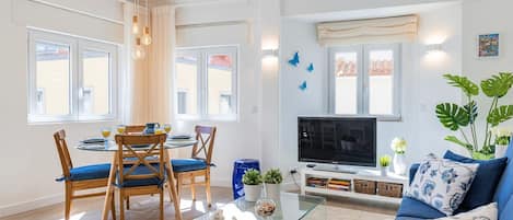 Modern and comfortable living area with a versatile sofa bed, a sleek TV for entertainment, refreshing air conditioning, and a dining table #modern #entertainment #portugal #pt #cascais