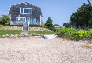 Back of the home with a large deck and its own private beach with ocean access!