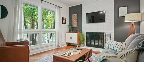 Living room with full size couch, recliner. Games and books inside the cabinet. 