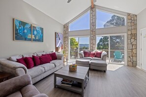 Sunny and bright open concept living room with cathedral windows.