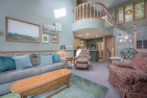 Main living area with entry level balcony and kitchen pictured