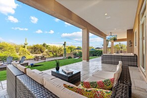 Covered patio during the day. 2 Sofa's and a mounted TV