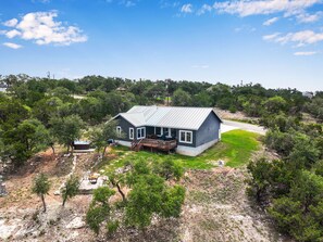 Aerial view of the rear of the home showing the location of the hot tub and fire pit.