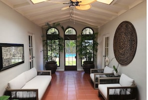 Breezeway with seating between dining room, bedrooms, and backyard & pool