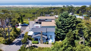 Aerial view of house with dunes and beach in background.