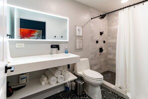 Newly renovated bathroom with subway marble tile, heated mirror, and Lusso stone sink.