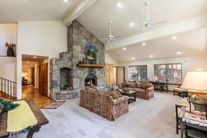 The spacious great room, featuring a stone fireplace and plenty of seating.