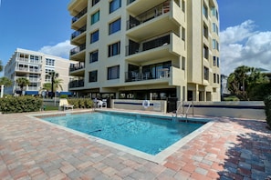 Gorgeous pool with many tables and lounge chairs.  