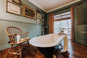 Indulge in a leisurely soak in the clawfoot bathtub, opening the doors and enjoying leafy views out to the surrounding landscape. 
