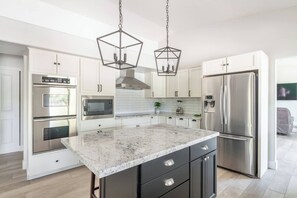 Modern-style kitchen with stainless steel appliances and marble countertops