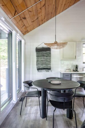 Modern dining for four with custom pendant light and handmade wall art