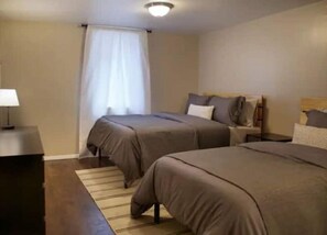 Bedroom 2 - 1 full bed, 1 twin bed, dresser, closet and work space.