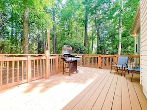 Uncovered back porch with seating and BBQ for outdoor cooking