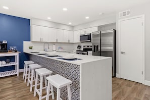 Gather around the stylish kitchen bar, a perfect spot for casual dining, socializing, and enjoying a morning cup of coffee.