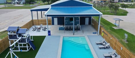 Aerial of Pool, Outdoor Kitchen with Bar, His/Her Half-Bathrooms and Playscape