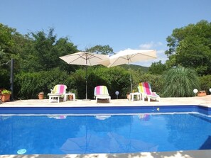 Sideview of pool with sunloungers and parasols for up to 8 guests