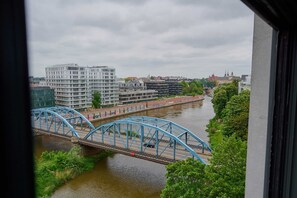 A beautiful view from the apartment window overlooking a nearby bridge and the flowing river.
