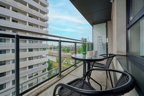 A balcony with a seating area and a view of the surrounding urban landscape, perfect for enjoying fresh air.

