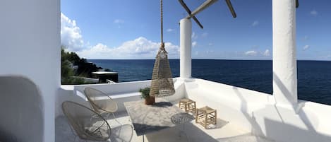 the Aeolian overlooking terrace on cobalt blue sea and  Strombolicchio islet.
