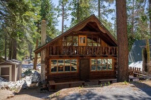 The view of the front of the home tucked amidst the trees.