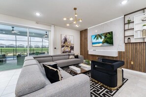 Relax in this modern living room with a cozy sectional, sleek decor, and easy access to the outdoor patio.