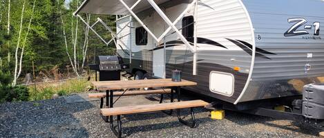 Picnic table, awning, firebowl, propane bbq, camper exterior