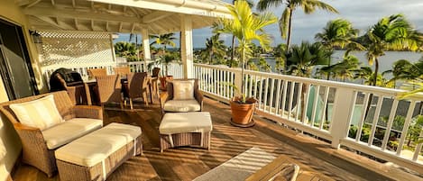 Large balcony with lounge and outdoor dining areas.