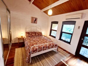 Main bedroom with queen bed, aircon and balcony