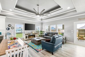Open living room, dining, kitchen. Enjoy natural light, view and 70" Roku TV.