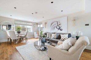 Spacious lounge with 55" TV, A/C & open-plan kitchen for relaxed luxury.