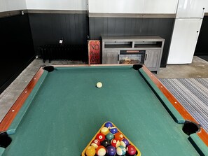 Remodeled game room with pool table and ping pong table and electric fireplace