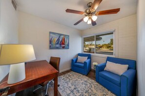 Office with comfortable seating, work desk, and door for privacy