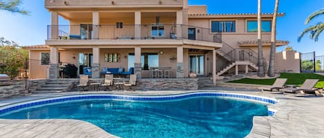 Gorgeous resort-style backyard with sparkling blue pool, spa and lounge chairs. 