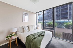 The master bedroom with a queen-sized bed, plush pillows.