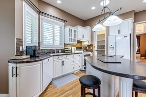 Kitchen area and pantry with coffee machine, spices, center counter, fridge, dishwasher, electric cooking range and range hood