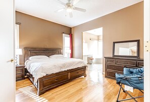 A large master bedroom with a huge ensuite bathroom and a king bed