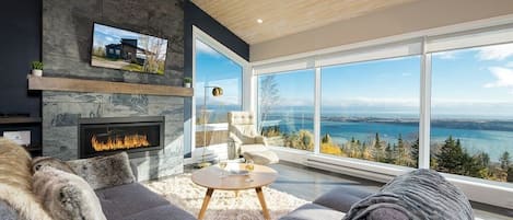 Living room with gas fireplace and large windows with view