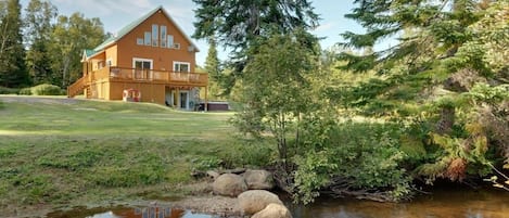 Outside view of cottage, yard and river
