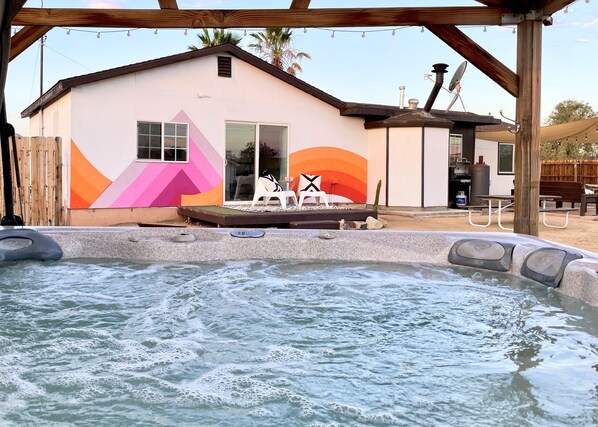 View of back porch from the jacuzzi is a nice touch
