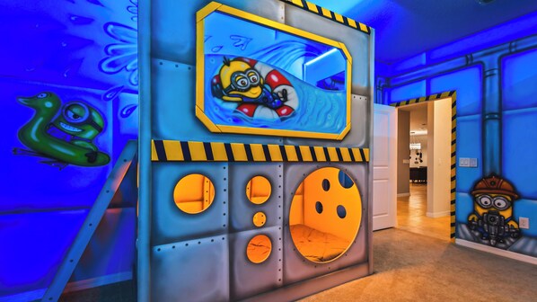 Minions-themed bunk room with bright murals and cozy pods for a fun-filled stay.
