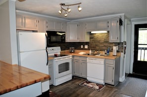 Beautiful full kitchen with refrig, over/stove, dishwasher, pots/pans, utensils