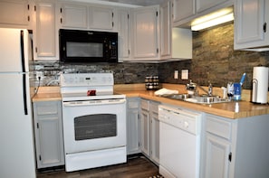 Kitchen with drink filter on water tap, Brita, microwave, dishes/glasses etc...