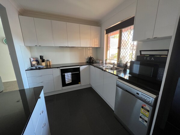 Fully contained kitchen with fridge, microwave, hot plates, oven, dishwasher.