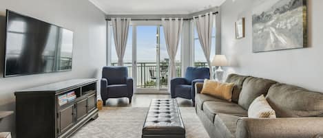 Living room looking out balcony window. Queen sleeper sofa.